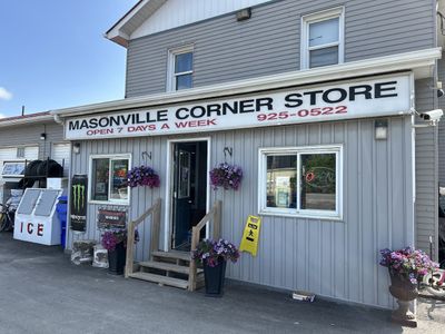 Exterior of Masonville Corner Store with gas pumps at dusk